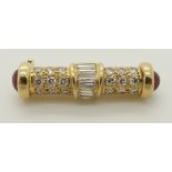 A bright yellow metal diamond and ruby brooch of baton shape set with brilliant cut and baguette