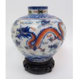 A Chinese Wucai globular vase painted with dragons and precious objects amongst clouds beneath a