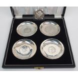 A Chinese silver set of four coin ashtrays with shaped rims and stamped, Sterling, Hong Kong, 6oz