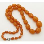 A string of amber coloured beads semi opaque orange in colour, largest bead 24.8mm x 20.4mm,