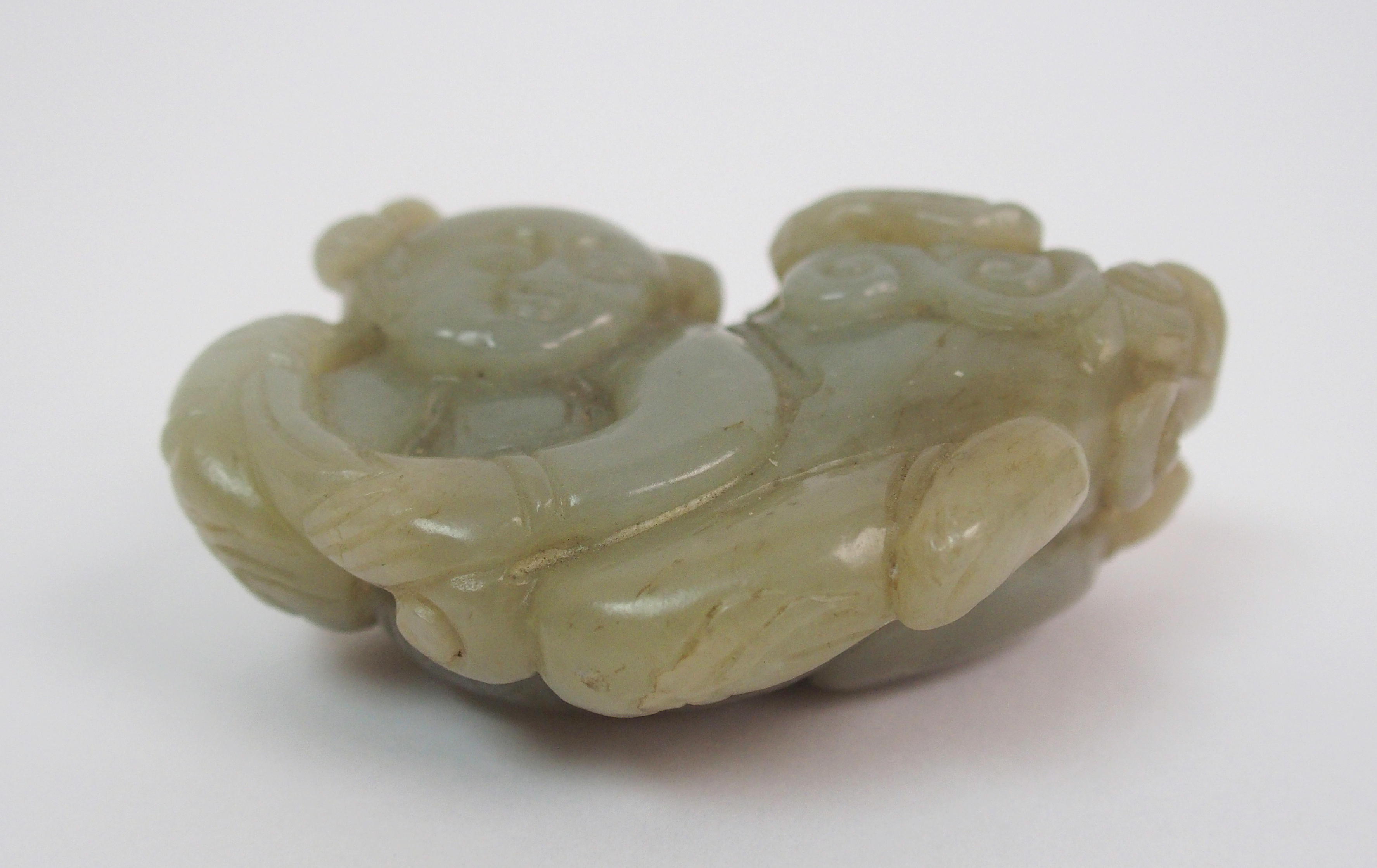 A Chinese jade carving of a child lying and holding lingzhi frond, 7cm wide - Image 3 of 10