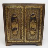 A Canton export black and gold lacquered cabinet painted with traditional scenes with a pair of