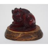 A Japanese amber coloured netsuke of a seated boar signed, 4cm wide