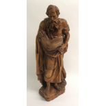 An early 20th century carved wood figure of a biblical scholar the standing figure dressed in
