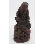 A Chinese bamboo figure of a fisherman seated on a rock above a young boy holding a fish amongst