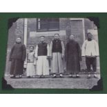 A Chinese photograph album comprising; 8 x 11cm images of interiors, tug of war, chapel, native