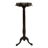A mahogany torchere with pierced gallery above a fluted column and acanthus leaf on tripod scroll