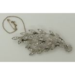 A white metal diamond brooch in the shape of three leafed stems from a circlet set with estimated