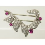 A diamond and ruby brooch set throughout in white metal. length 3.1cm x 2.3cm, weight 5.8gms