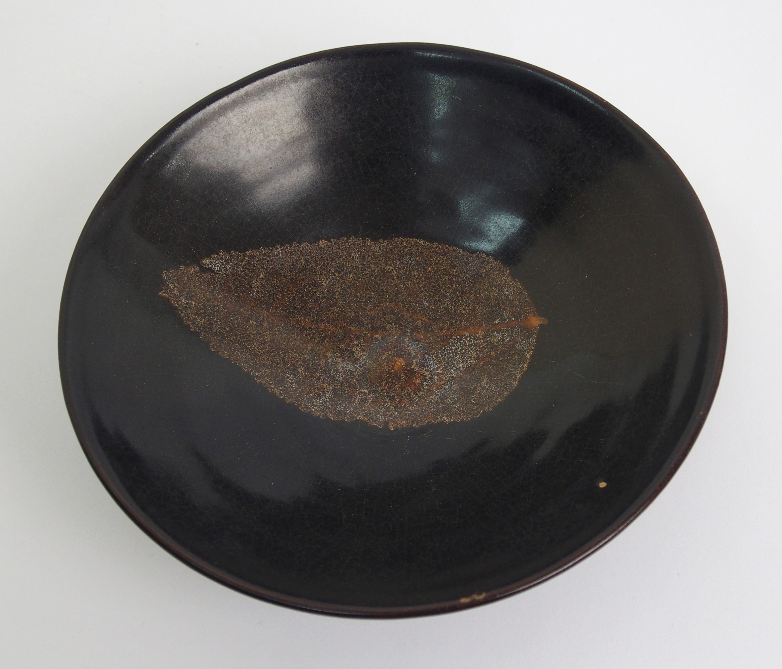 A Chinese black glazed bowl with single leaf decoration, 15.5cm diameter