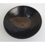 A Chinese black glazed bowl with single leaf decoration, 15.5cm diameter