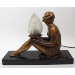 An Art Deco spelter lamp modelled as a seated semi clad female, patinated, upon veined marble