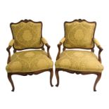 A set of six Spanish walnut armchairs the scrolling frames carved with scallop shells above outswept