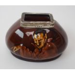 A Royal Doulton Kingsware Mephistopheles match holder and striker by Noke, with silver rim, dated