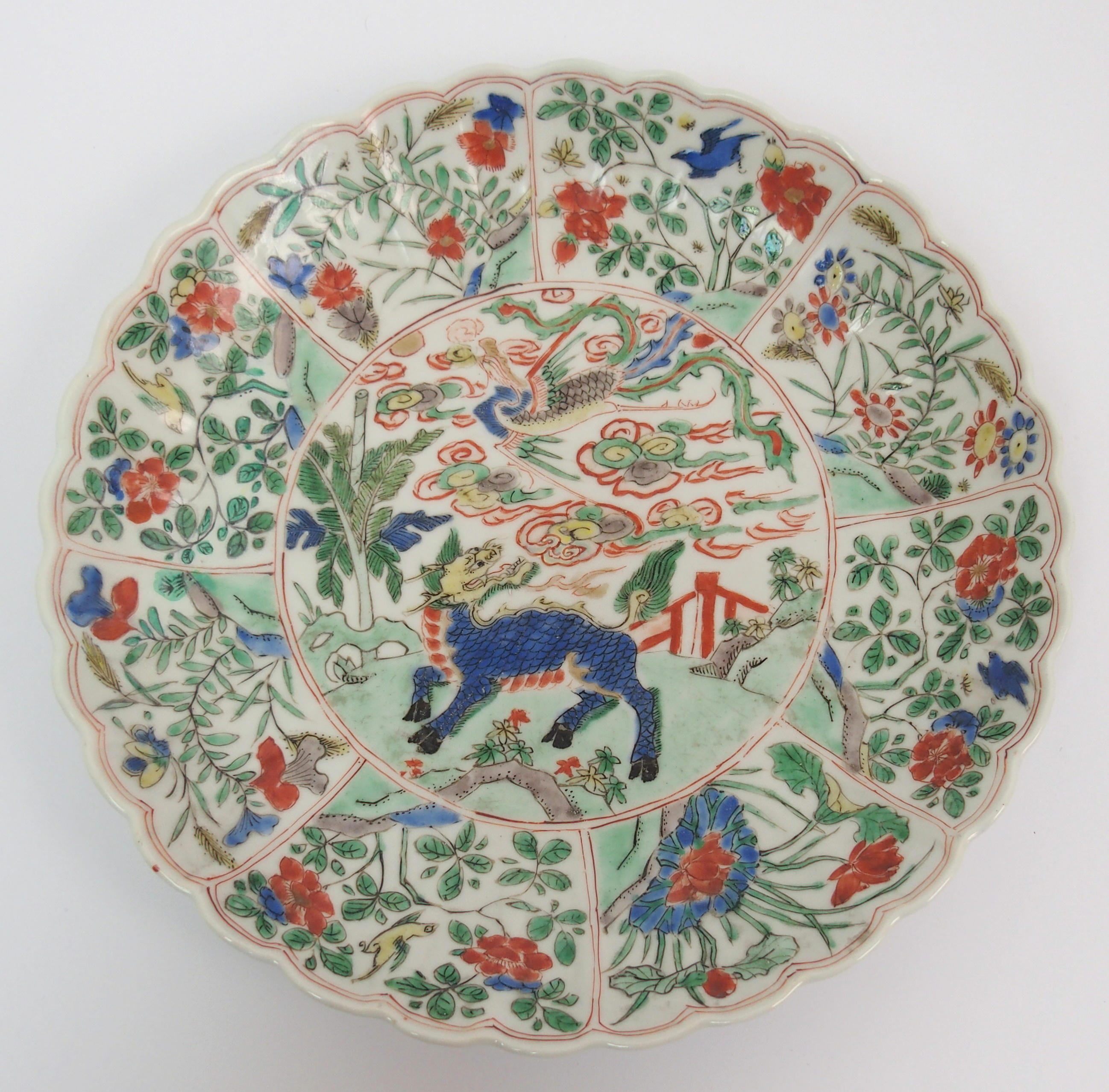 A Chinese lobed dish painted with a kylin and phoenix within panels of birds amongst flowering