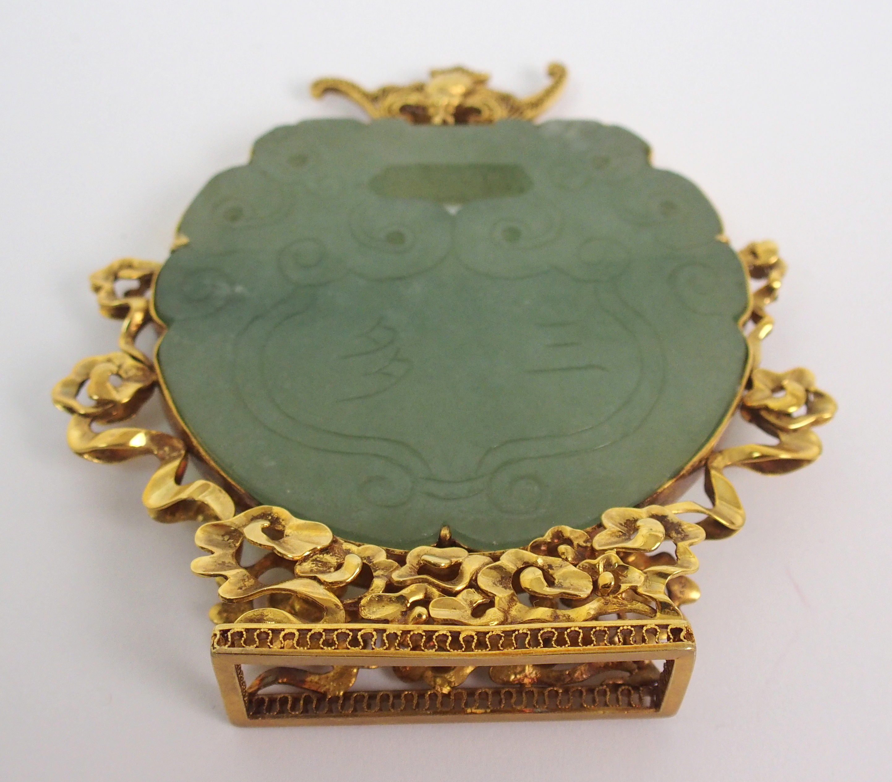 A Chinese hardstone pendant disc carving with conjoined grotesques, set within a gilt metal - Image 9 of 10