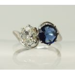 An 18ct white gold and platinum diamond and blue gem twin stone ring the old cut diamond is