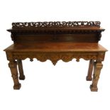 A Victorian oak hall table the pierced foliate rail above a shelf supported by griffins, lion mask