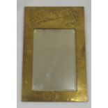 A Glasgow School Arts and Crafts style mirror of rectangular form with repousse decoration of a