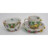 A Meissen cabinet cup and saucer painted and encrusted with flowers and birds and a similar sugar