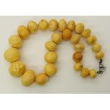 A string of amber coloured beads of rough round shapes largest approx 2.3cm to smallest 1.2cm,