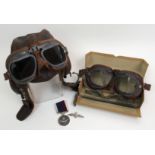 An Airman's leather flight cap with attached goggles a boxed pair of goggles, an RAF sweetheart