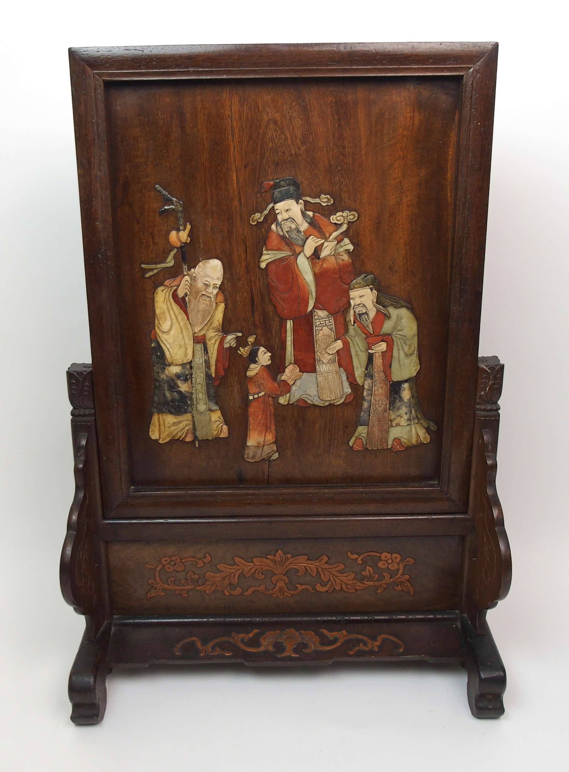 A Chinese table screen decorated with figures in hardstones on a stand carved with foliage, 59cm