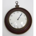 A Regency circular sedan clock the white enamel dial with black numbers in an inlaid wooden mount