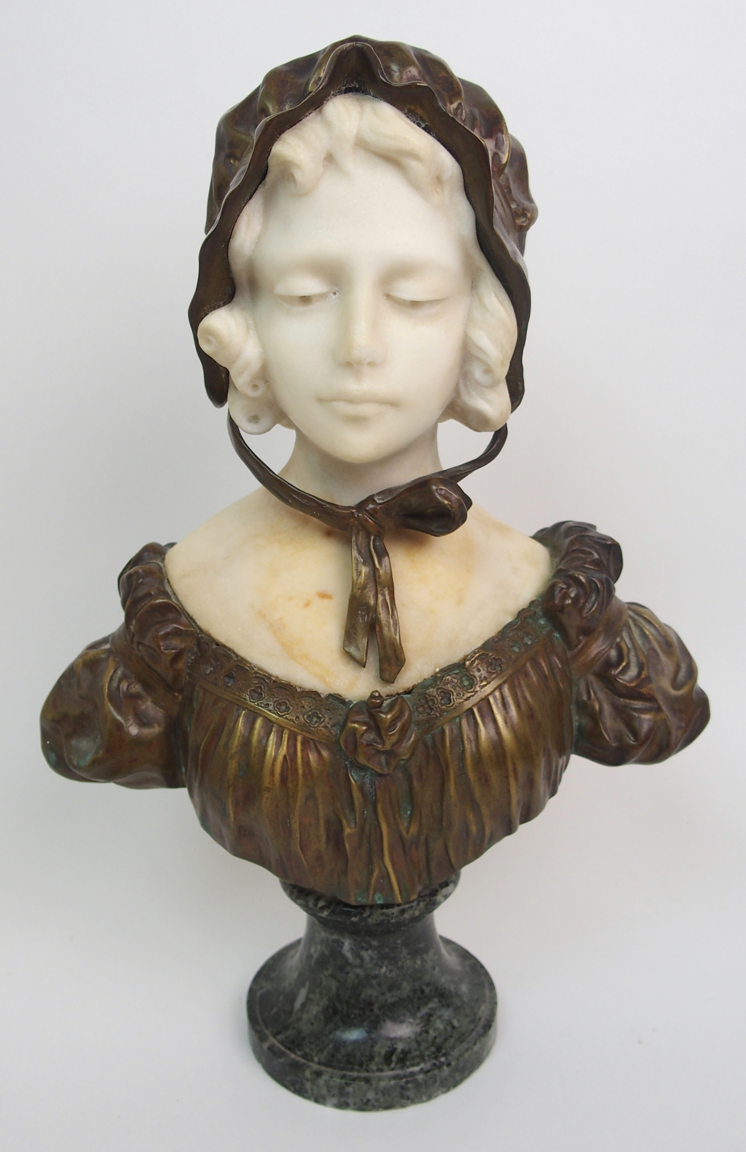 Affortunato Gory (active 1895-1925) Bronze and alabaster bust of a girl modelled wearing a bonnet,