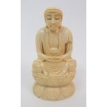A Japanese ivory okimono of Buddha seated in the lotus position on a lotus throne, signed to the