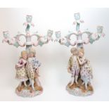 A pair of Continental porcelain figural candelabra each modelled as a courting couple in 18th