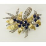 An 18ct gold sapphire and diamond brooch in both white and yellow gold with a floral theme, length