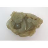 A Chinese jade carving of a child lying and holding lingzhi frond, 7cm wide