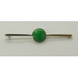 An 18ct white gold bar brooch set with a Chinese green hardstone diameter of hardstone 1.1cm, length