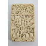 A Canton carved ivory card case carved all over with figures amongst pagodas and trees and
