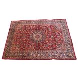 A red ground meshed rug with blue central medallion, 350cm x 243cm