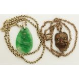 A Chinese green hardstone pendant and a Japanese demon mask pendant the hardstone pendant is