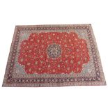 A red ground Sarough rug with blue central medallion and border, 293cm x 383cm