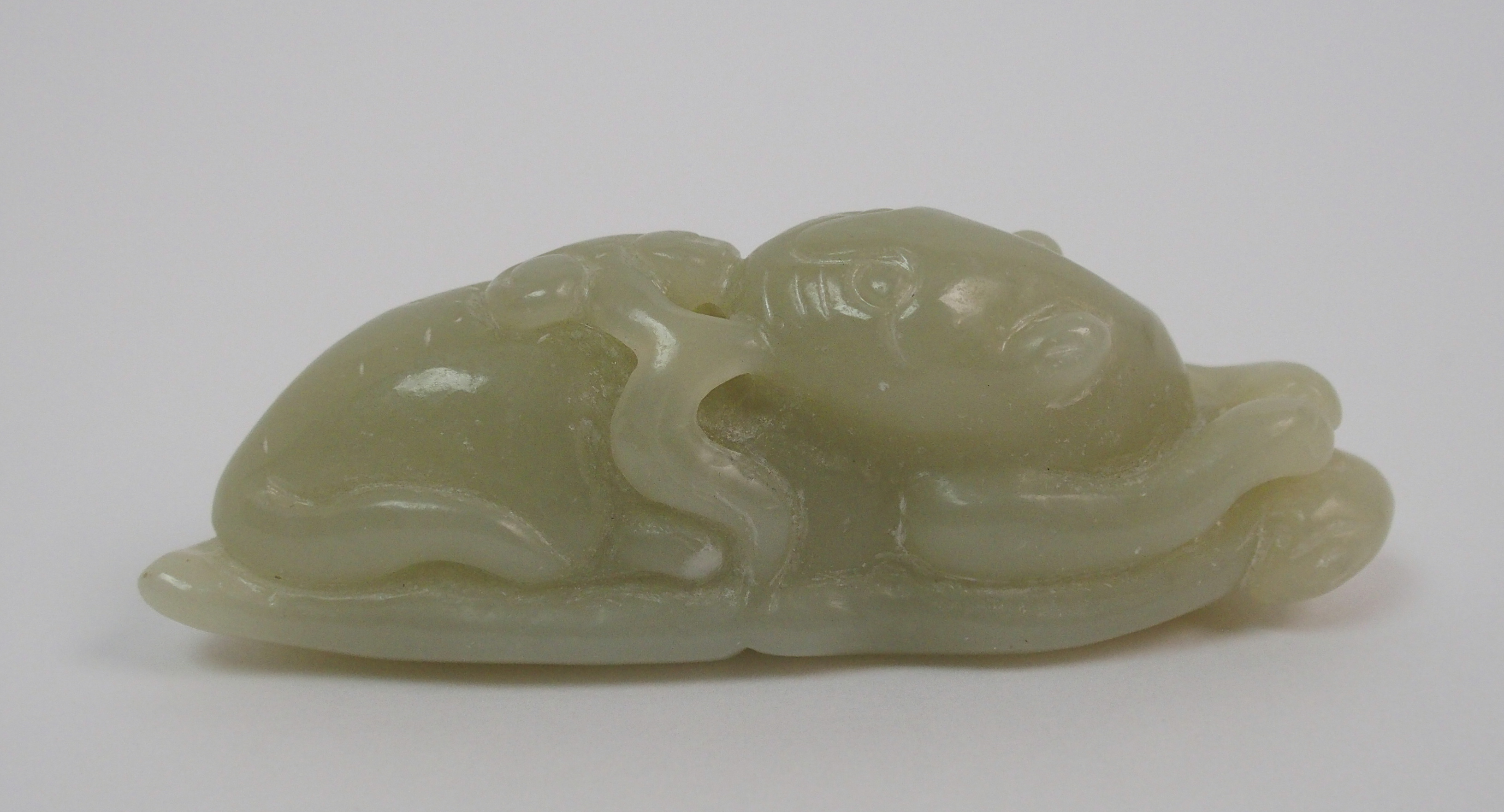 A Chinese hardstone carving of a feline recumbent with scroll in mouth and resting on a leaf, 7. - Image 2 of 10