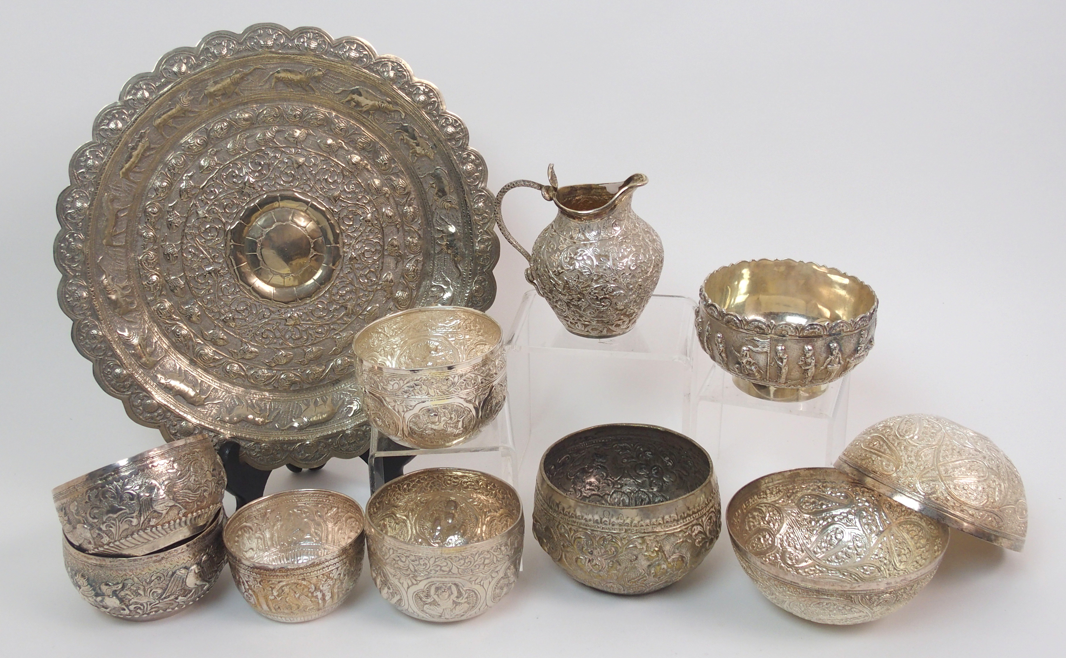 Nine Eastern white metal bowls 7.5 to 9.5cm diameter, a salver decorated with animals 26cm