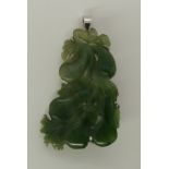 A 14ct white gold pendant brooch set with a Chinese green hardstone carved with fruit, length 4.