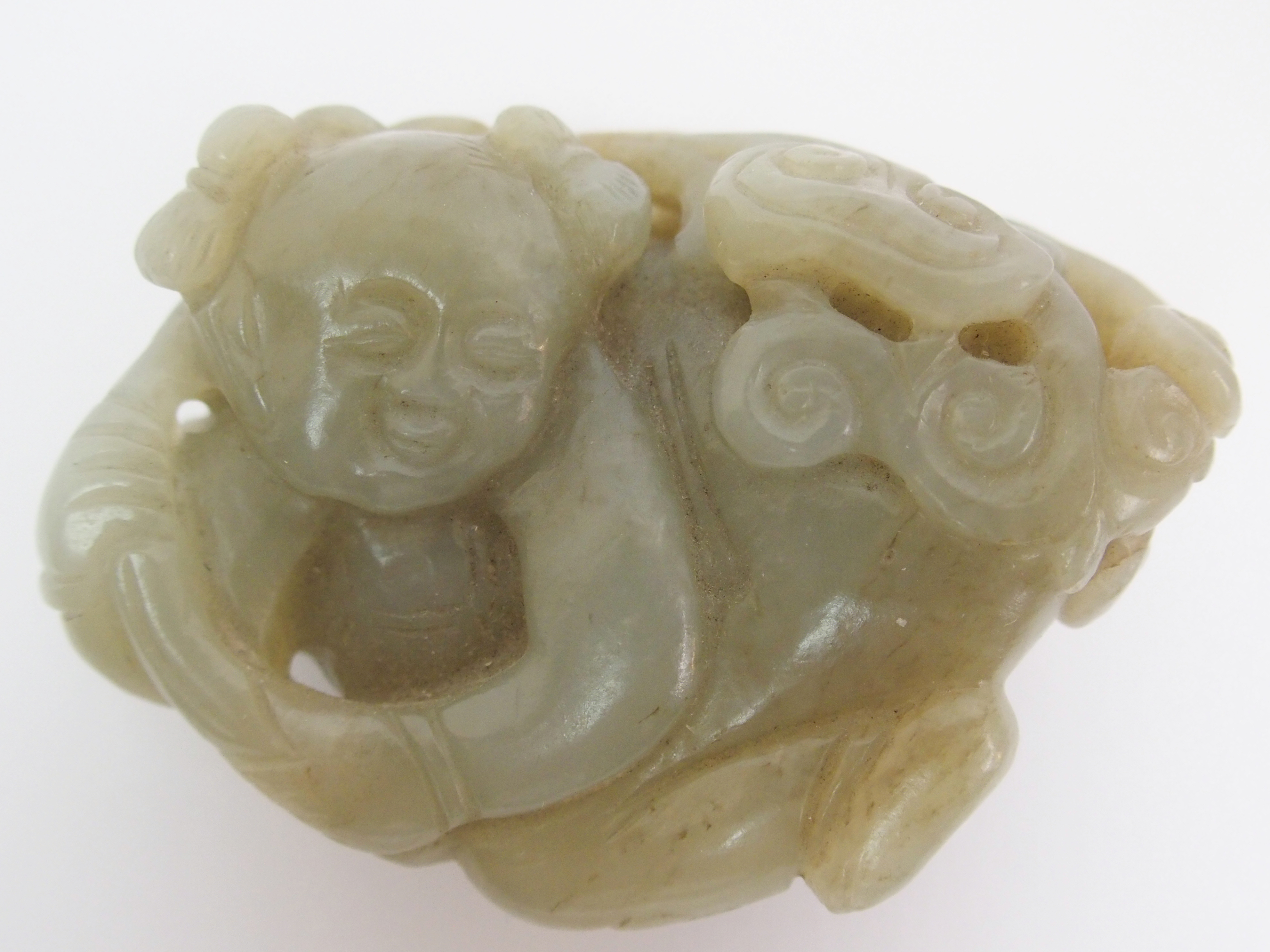 A Chinese jade carving of a child lying and holding lingzhi frond, 7cm wide - Image 2 of 10