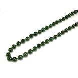 A dark green jade bead necklace,