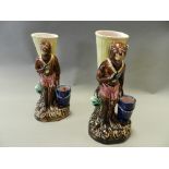 A pair of continental majolica figural spill holders modelled as standing monkeys carrying baskets