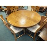 A modern light oak extending dining table and four chairs