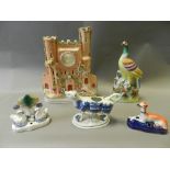 Staffordshire pottery to include a castle watch stand, a figure of an exotic bird,