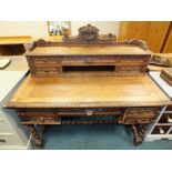 A late Victorian oak kneehole desk with lion mask handles