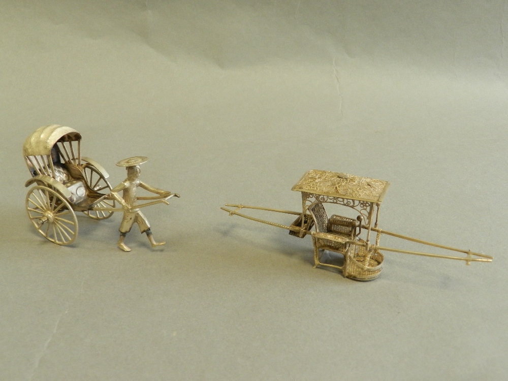 A Chinese white metal model of a man pulling a rickshaw together with a white metal miniature sedan