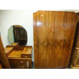 A mid 20th century walnut veneered three piece bedroom suite comprising a wardrobe,