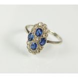 A diamond and sapphire panel cluster ring,